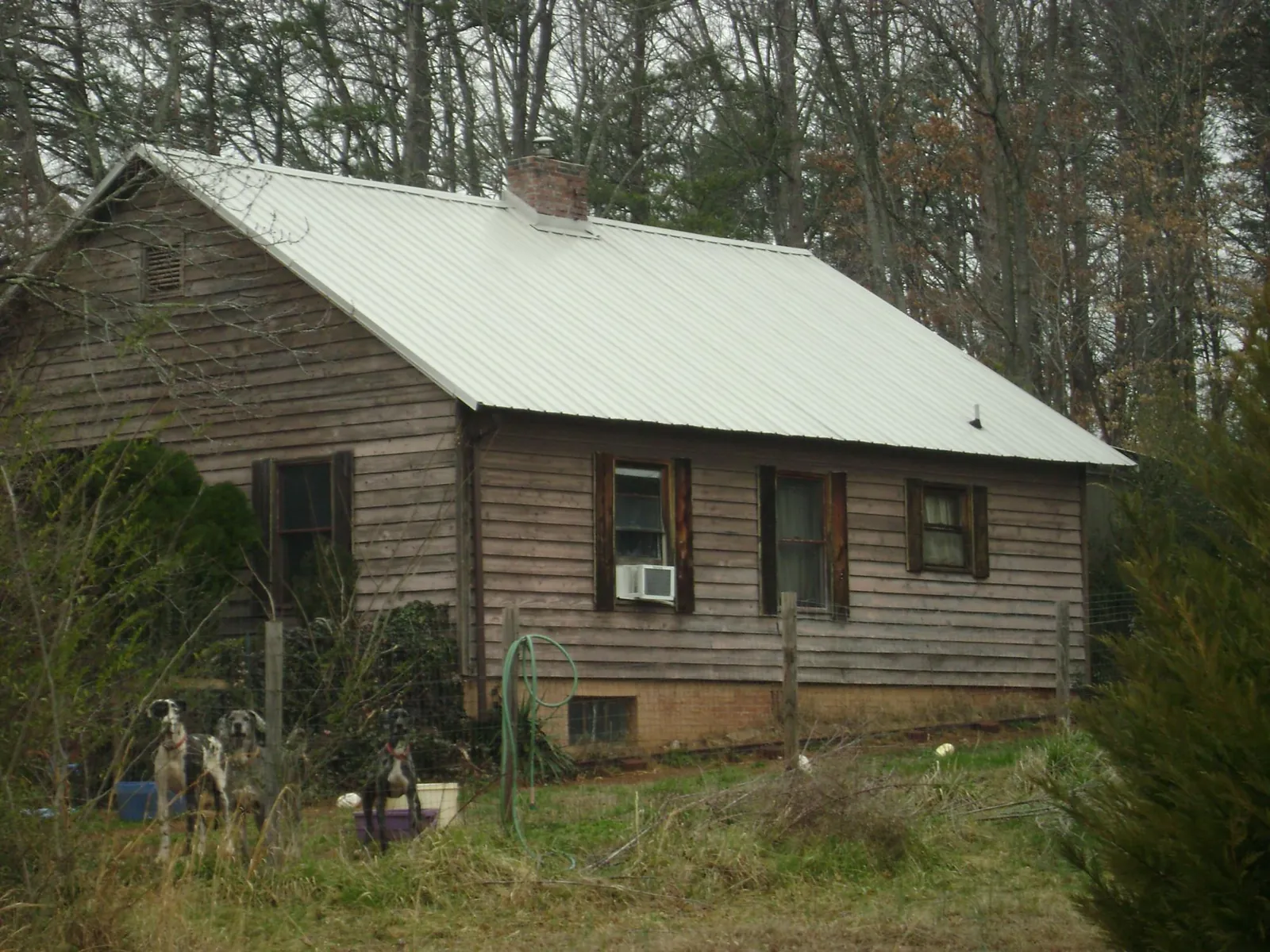 White metal roof on an old wood sided farmhouse, from a Asphalt Shingle Roof Repair job in Lumberton
